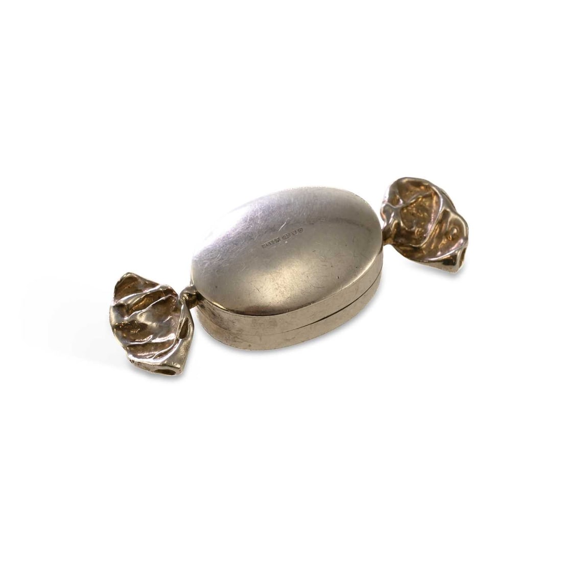 A CONTINENTAL NOVELTY SILVER PILL BOX IN THE FORM OF A SWEET: A CONTINENTAL NOVELTY SILVER PILL BOX IN THE FORM OF A SWEET import marked for Martin Gerald & Sid Adler, London 2001, cast in the form of a hinged wrapped sweet. 6cm wide, 0.5 troy ounces