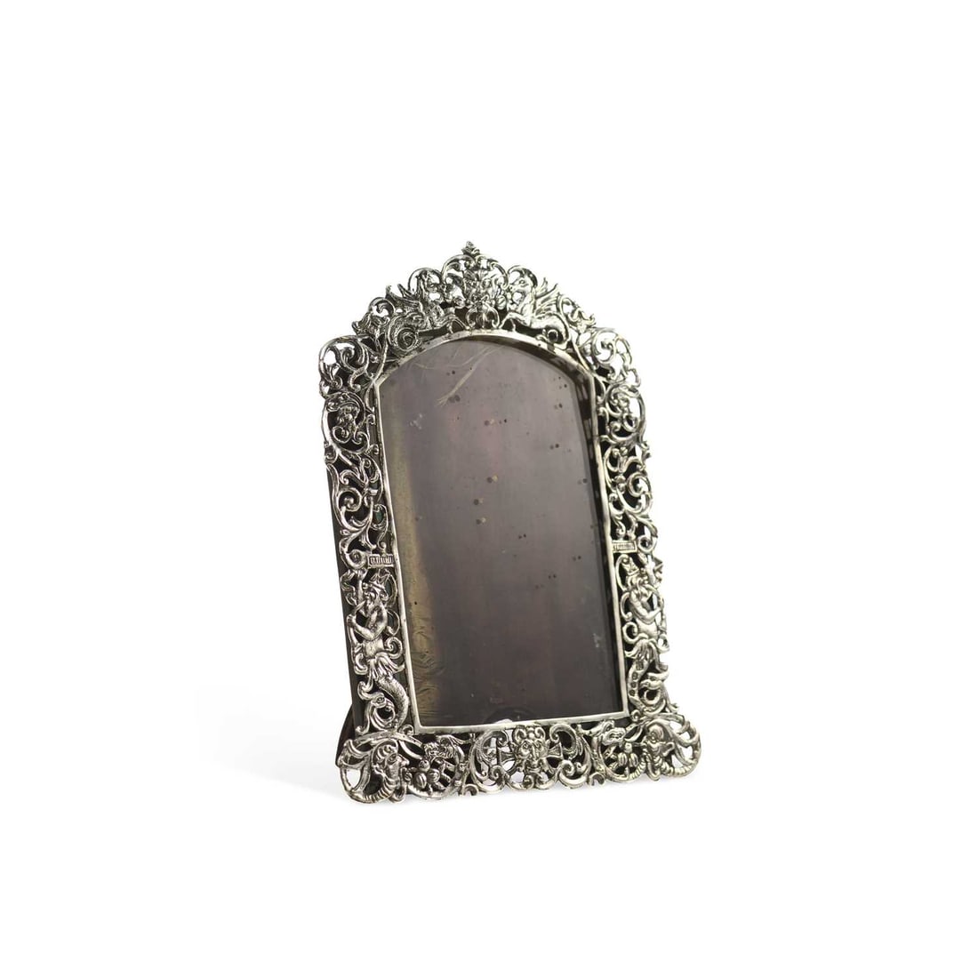 A LATE VICTORIAN SILVER PHOTOGRAPH FRAME: A LATE VICTORIAN SILVER PHOTOGRAPH FRAME by Rosenthal, Jacob & Co., London 1891, Rd 57109, of arched rectangular form, pierced decoration in the form of mythological and classical figures, easel
