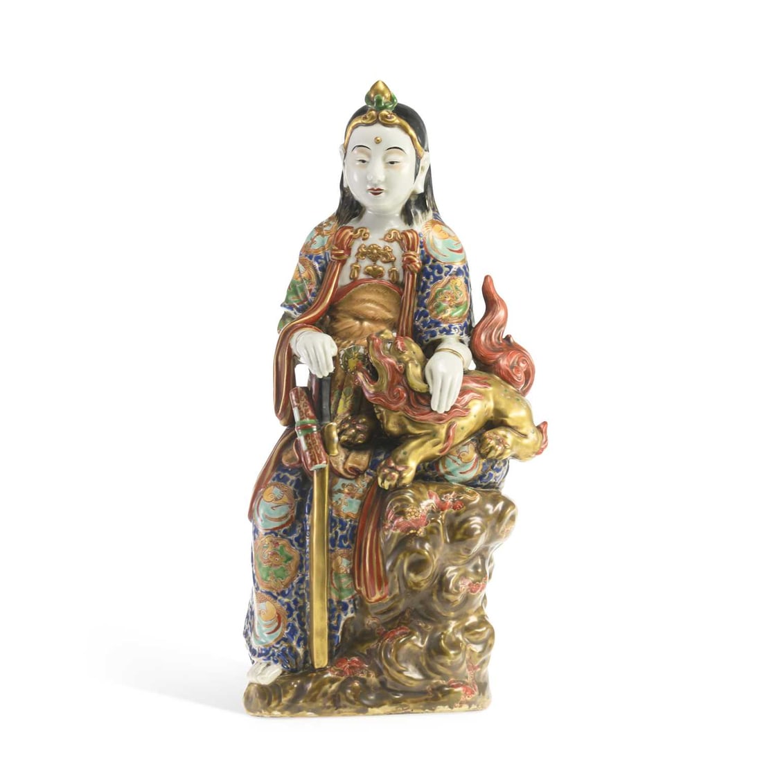 A JAPANESE KUTANI PORCELAIN GROUP OF KANNON MEIJI PERIOD: A JAPANESE KUTANI PORCELAIN GROUP OF KANNON MEIJI PERIOD modelled as the Goddess of Mercy seated upon flowering rockwork, accompanied by a shishi, decorated in typical enamels. 46cm high