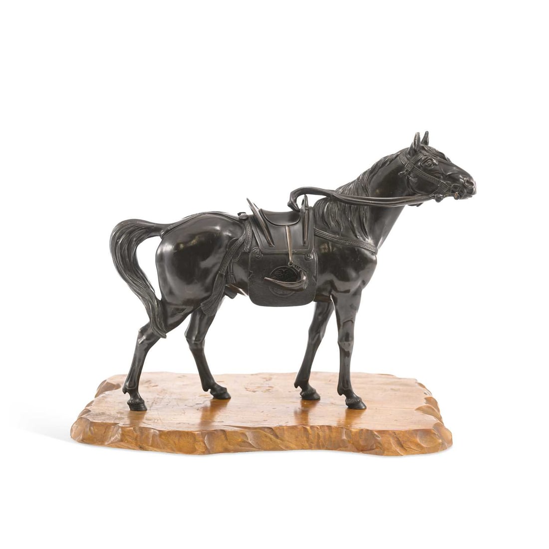 A JAPANESE BRONZE OKIMONO OF A HORSE MEIJI PERIOD: A JAPANESE BRONZE OKIMONO OF A HORSE MEIJI PERIOD finely cast wearing full tack, the saddle cloth engraved with Mons, signed Atsuyoshi for the Maruki Company with seal mark to the underside, original 