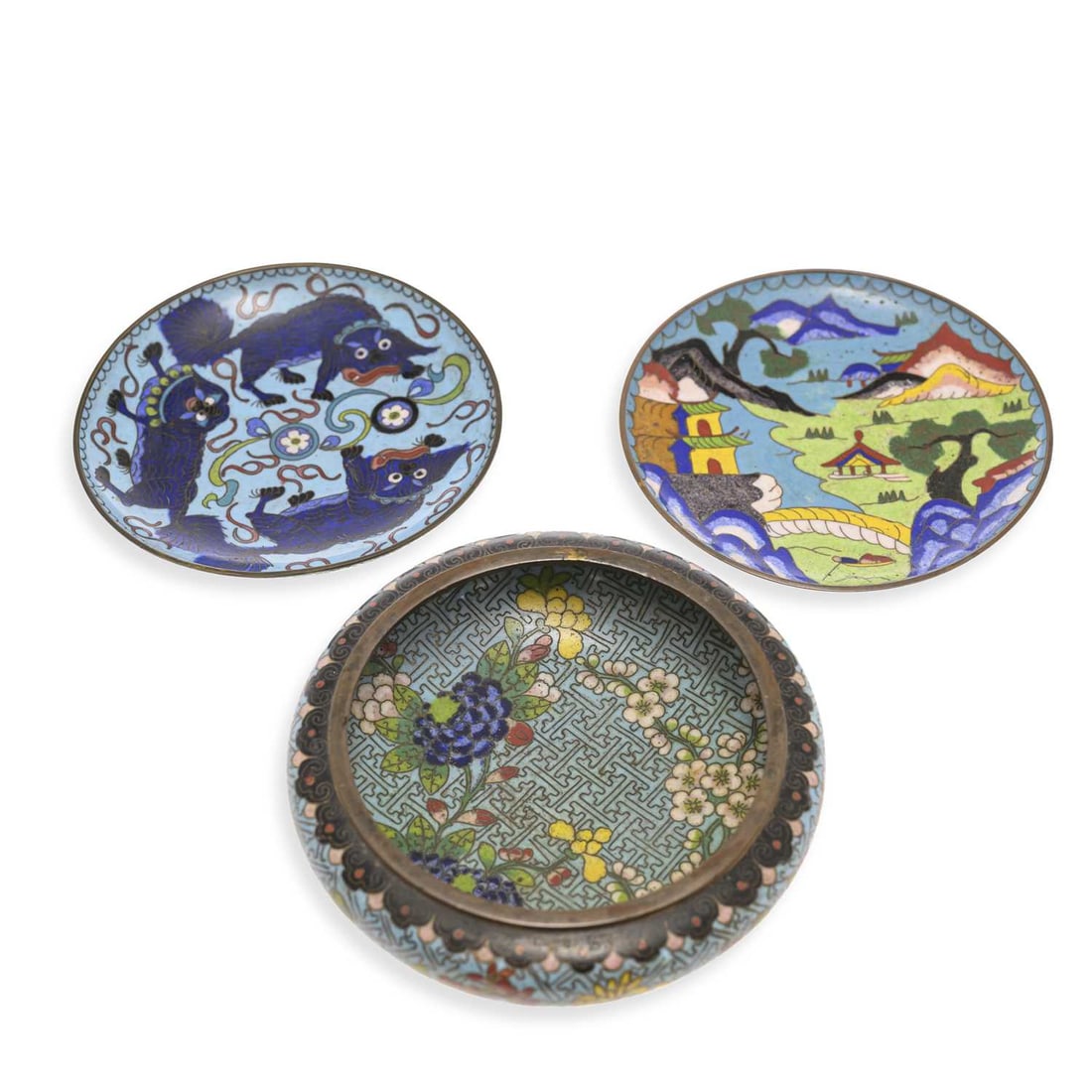 THREE PIECES OF CHINESE CLOISONNÉ: THREE PIECES OF CHINESE CLOISONNÉ comprising of a brush washer decorated with flowering plants; a saucer enamelled with lion dogs; and a saucer with a river landscape. (3) Brush washer 14.5cm diamete