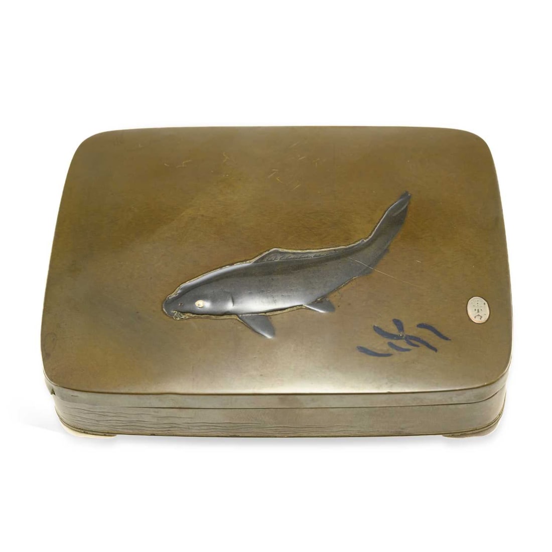 A JAPANESE INLAID BRONZE BOX MEIJI PERIOD: A JAPANESE INLAID BRONZE BOX MEIJI PERIOD the cover inlaid with a large silver carp, swimming above a shawl of fish, the base engraved with waves, and set upon cabriole feet, signed to the base. 12.2c