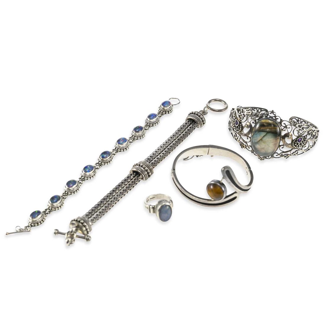 A GROUP OF SILVER JEWELLERY: A GROUP OF SILVER JEWELLERY including a Sigi Pineda Mexican Taxco hinged bangle, with a swivel element set with diopside and tiger's eye cabochons; two Suarti bracelets; a Suarti ring; etc. (5) First 