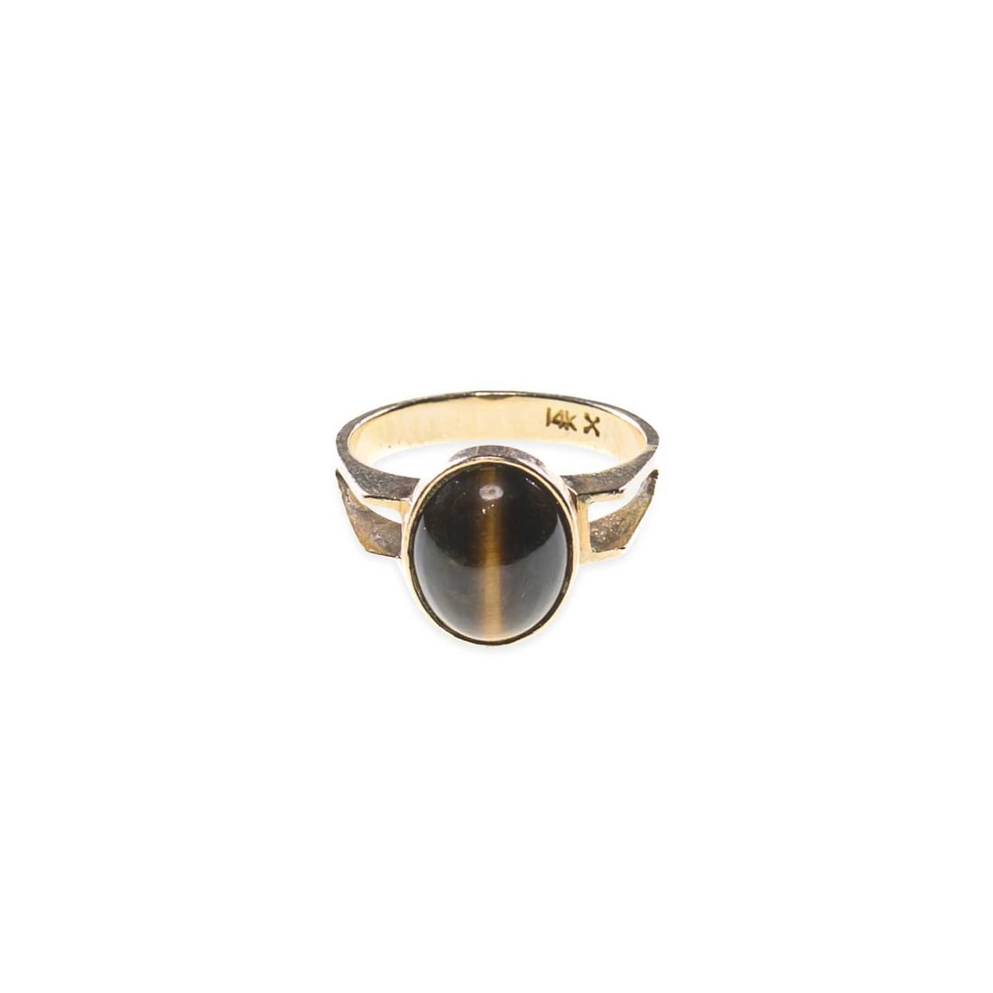 A TIGER'S EYE RING: A TIGER'S EYE RING an oval cabochon tiger's eye to angular split shoulders, stamped '14K'. Ring size M1/2, 4.1 grams Good condition