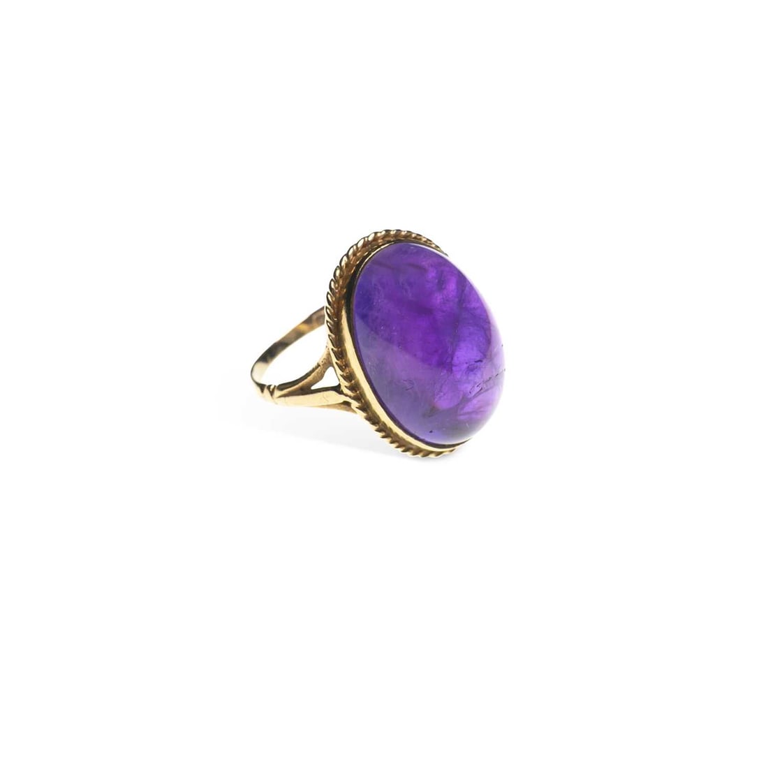 A 9 CARAT GOLD AMETHYST RING: A 9 CARAT GOLD AMETHYST RING an oval cabochon amethyst within a rope frame, to forked shoulders, hallmarked Birmingham 1989. Ring size L, 5 grams Good condition