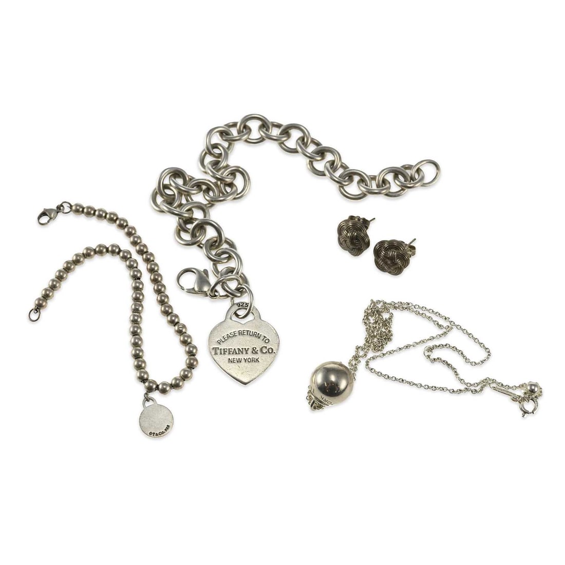 A GROUP OF TIFFANY & CO SILVER JEWELLERY: A GROUP OF TIFFANY & CO SILVER JEWELLERY comprising a curb link chain bracelet with a heart-shaped 'Return to Tiffany' charm, hallmarked; a beaded bracelet with a 'Return to Tiffany' circular tag, sta