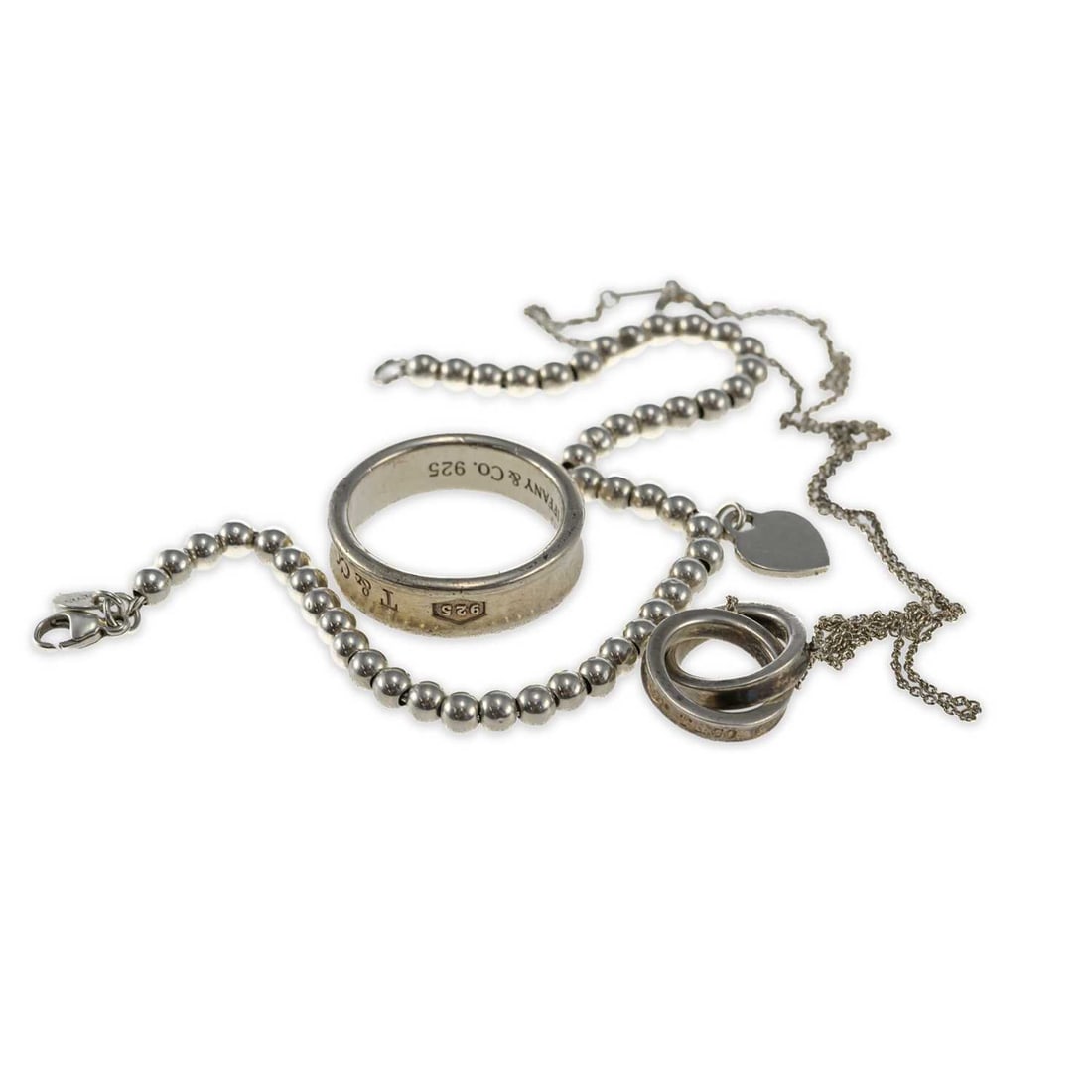 A GROUP OF TIFFANY & CO SILVER JEWELLERY: A GROUP OF TIFFANY & CO SILVER JEWELLERY comprising a beaded bracelet with a 'Please Return to Tiffany' heart tag set with a diamond, stamped 'Ag925'; an '1837' concave band ring, stamped '925'; and a