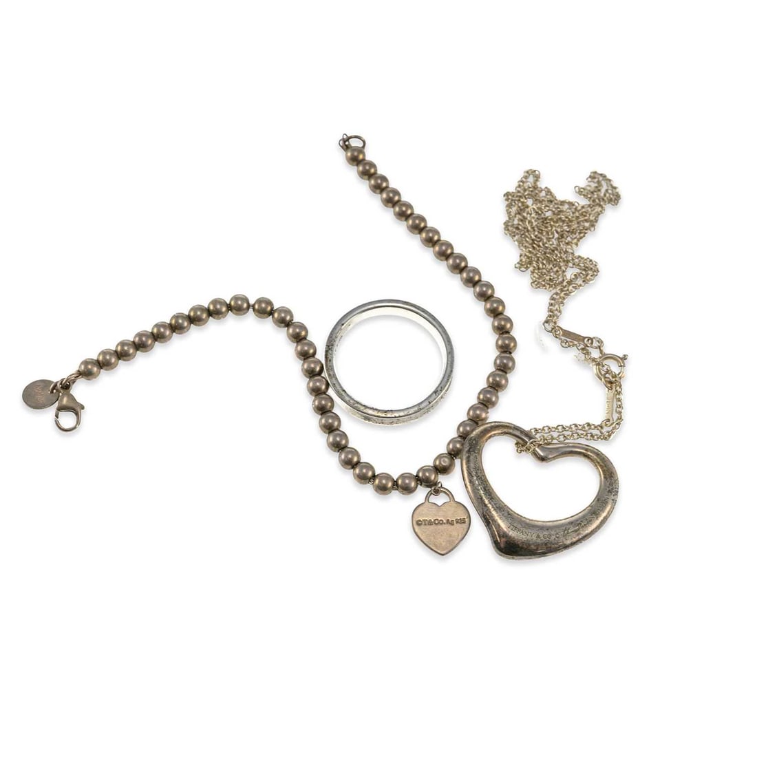 A GROUP OF TIFFANY & CO SILVER JEWELLERY: A GROUP OF TIFFANY & CO SILVER JEWELLERY comprising a beaded bracelet with a 'Please Return to Tiffany' heart tag; an Elsa Peretti Open Heart pendant necklace, stamped '925'; an 1837 band ring,