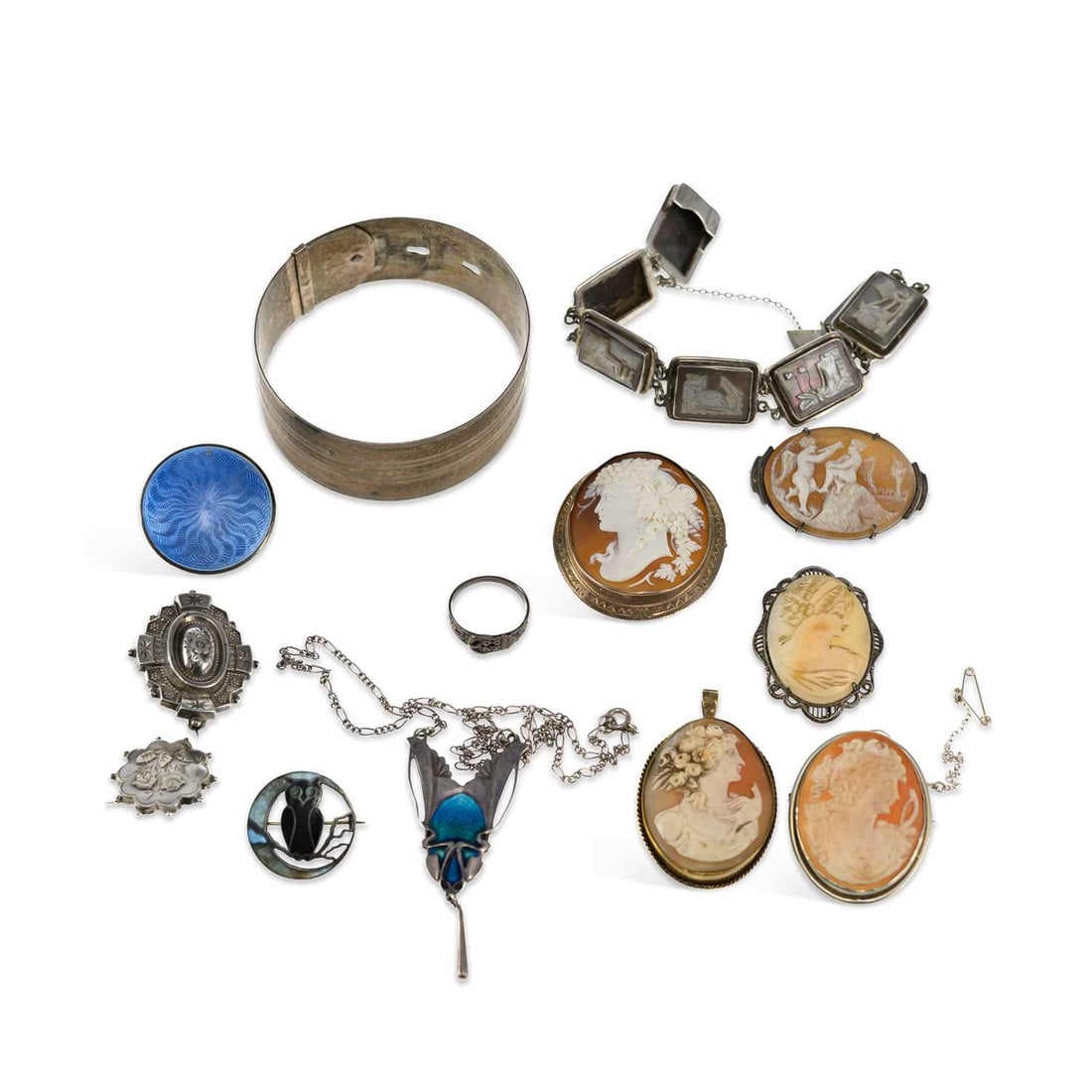 A GROUP OF ANTIQUE AND LATER JEWELLERY: A GROUP OF ANTIQUE AND LATER JEWELLERY including a silver and enamel brooch depicting an owl sat upon a branch within a crescent moon, by Charles Horner; a cameo brooch carved with a bacchante