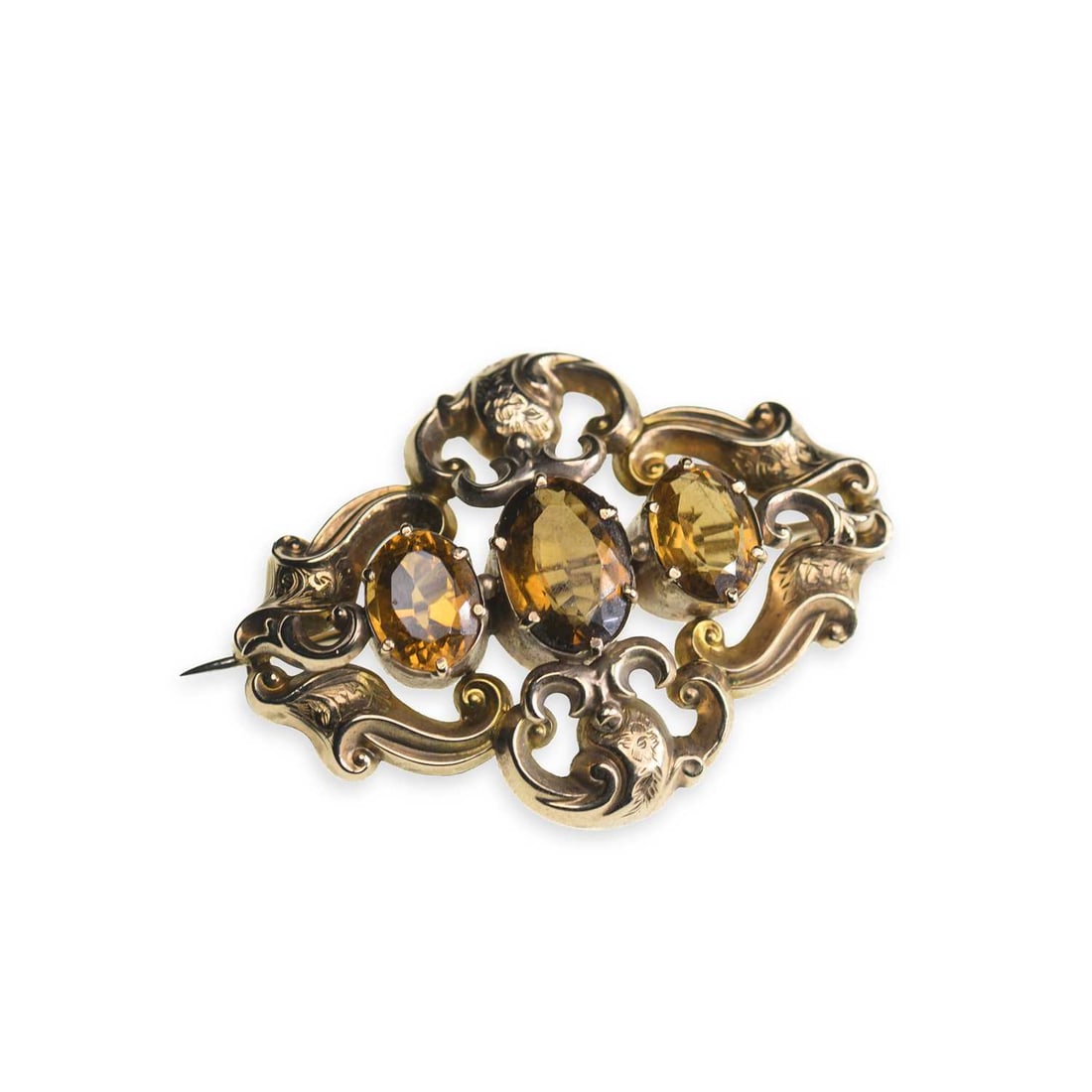A VICTORIAN CITRINE BROOCH: A VICTORIAN CITRINE BROOCH three graduated oval-cut citrine within a foliate scroll frame, stamped '9CT'. 5.5cm long, 9.2 grams Light general wear