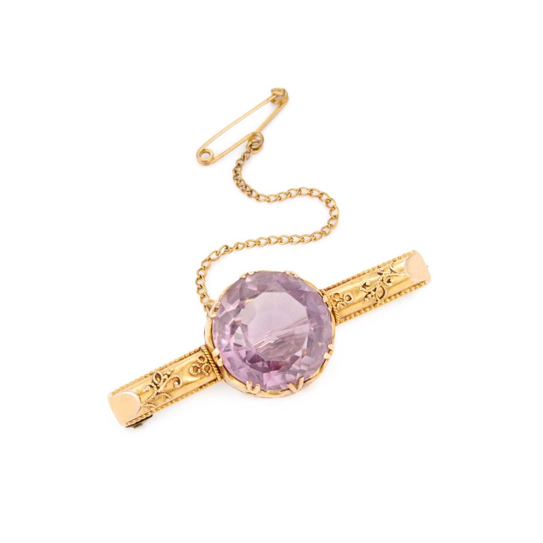 A VICTORIAN AMETHYST BROOCH: A VICTORIAN AMETHYST BROOCH a round-cut amethyst in a double-claw setting, to a cannetille decorated bar, unmarked. 4.7cm long, 7.8 grams Light wear to bar. Pin replaced with solder marks