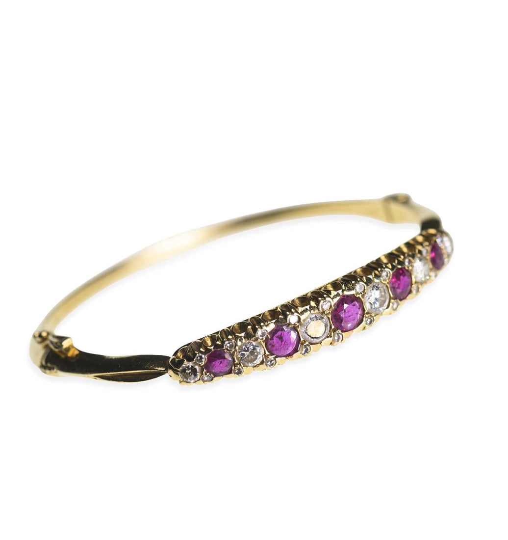 A RUBY AND DIAMOND HINGE-OPENING BANGLE: A RUBY AND DIAMOND HINGE-OPENING BANGLE graduated round-cut rubies spaced by round brilliant-cut diamonds and diamond accents, unmarked. Estimated total diamond weight 1.50 carat, 16cm inner circumfer