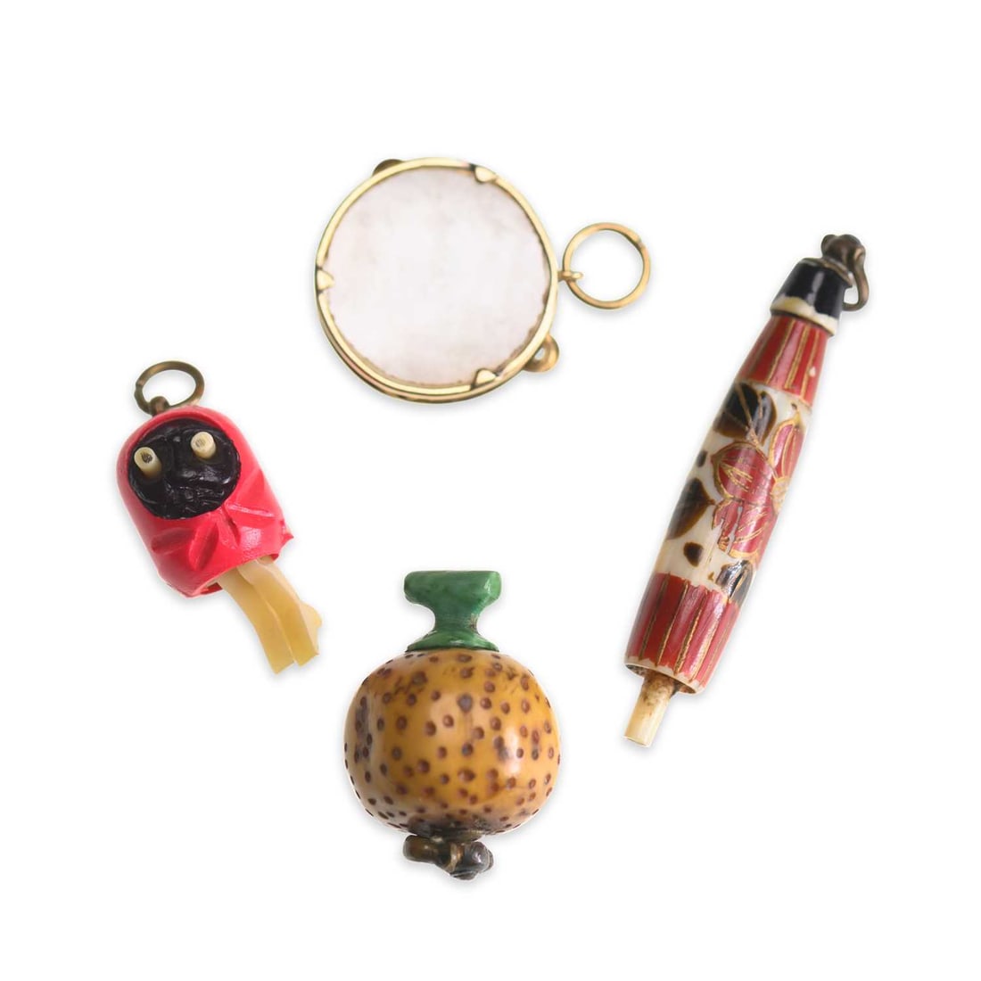 A GROUP OF EARLY 20TH CENTURY NOVELTY CHARMS: A GROUP OF EARLY 20TH CENTURY NOVELTY CHARMS including a parasol hidden dice charm; a gourd hidden dice charm; celluloid Kobe charm; and a mother-of-pearl tambourine charm, French 18 carat gold mark. 