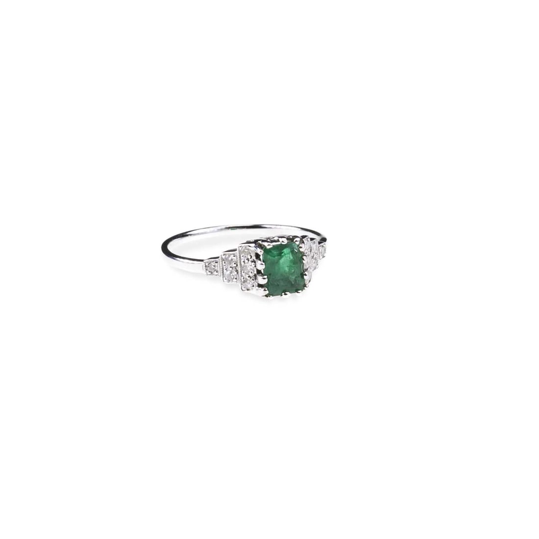AN EMERALD AND DIAMOND RING: AN EMERALD AND DIAMOND RING an octagonal-cut emerald to diamond-set milgrain stepped shoulders, indistinctly marked. Ring size M1/2, 2.3 grams Good condition