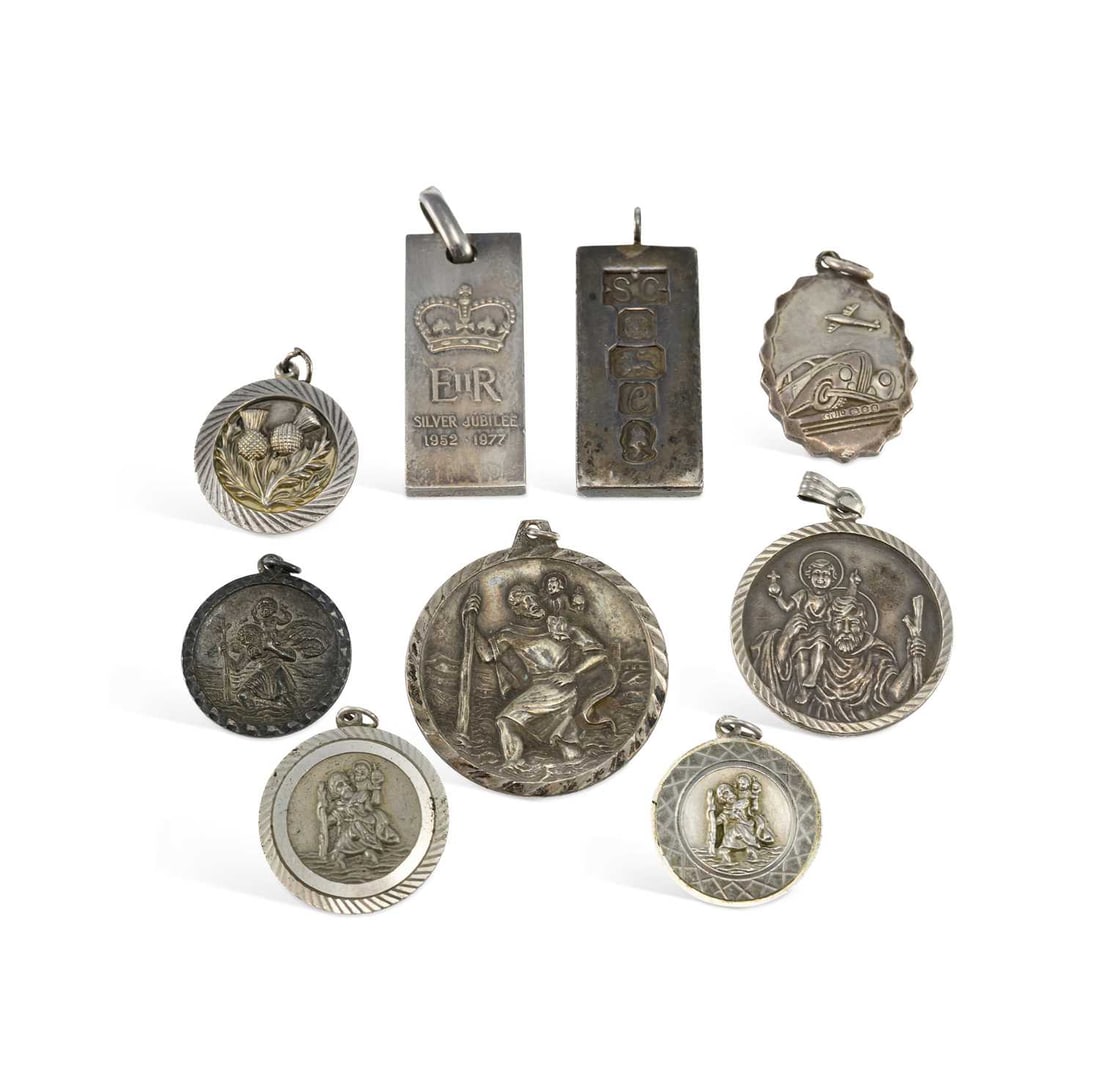 A GROUP OF SILVER PENDANTS: A GROUP OF SILVER PENDANTS including an oval St Christopher pendant with a fluted edge, by Georg Jensen, hallmarked; an Elizabeth II Silver Jubilee ingot pendant; etc. (9) First 3.3cm high, 134.8 gram
