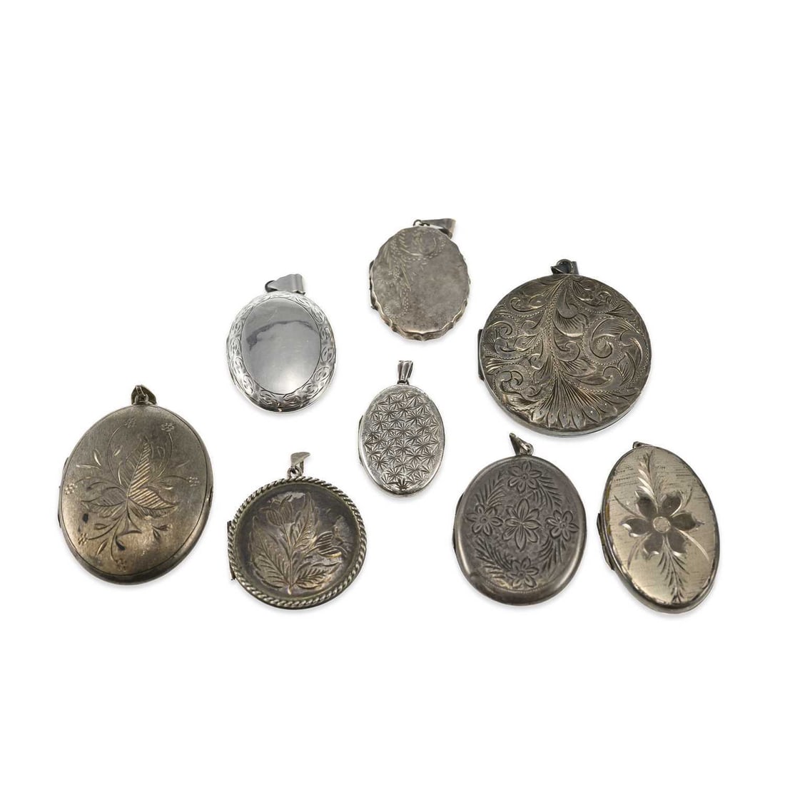 A GROUP OF SILVER LOCKET PENDANTS: A GROUP OF SILVER LOCKET PENDANTS including a large circular example engraved with scrolling foliage, hallmarked Birmingham; etc. (8) First 4.5cm diameter, 105 grams gross