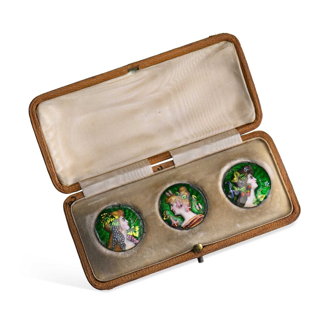 A CASED SET OF THREE FRENCH ART NOUVEAU ENAMEL BUTTONS: A CASED SET OF THREE FRENCH ART NOUVEAU ENAMEL BUTTONS each painted in enamels depicting a female portrait adorned with different flowers, Vigne, Fuchia and Fraises, on green guilloché enamel grounds