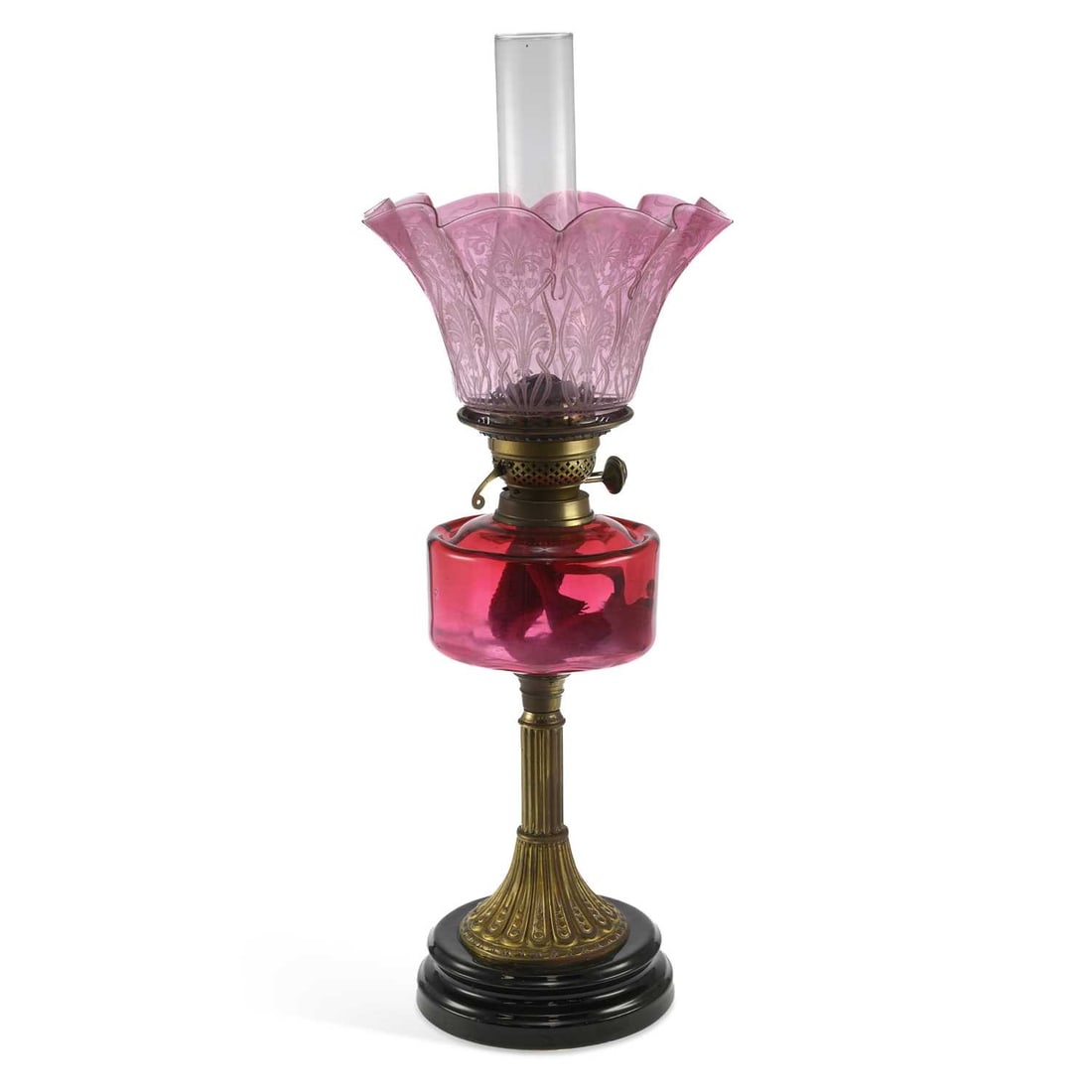 A VICTORIAN CRANBERRY GLASS AND BRASS OIL LAMP: A VICTORIAN CRANBERRY GLASS AND BRASS OIL LAMP with a foliate decorated tinted shade. 64cm high overall