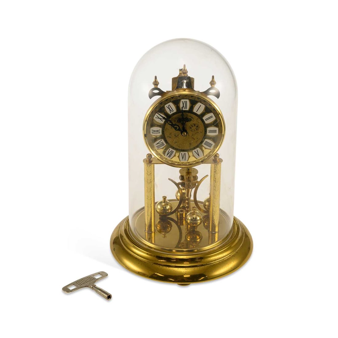 A 20TH CENTURY GERMAN GILT-BRASS TORSION CLOCK BY HALLER: A 20TH CENTURY GERMAN GILT-BRASS TORSION CLOCK BY HALLER the circular dial with Roman numerals, raised on four engraved columns above a four-ball pendulum, beneath a dome, with key. 28.5cm high overal