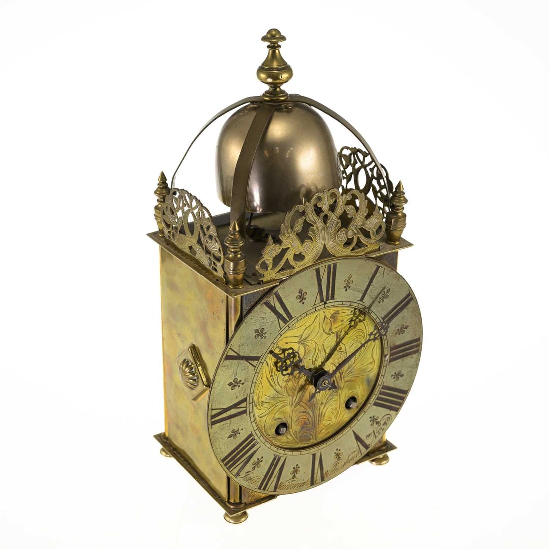 A BRASS LANTERN CLOCK BEARS SIGNATURE WAINWRIGHT, WELLINGBORO: A BRASS LANTERN CLOCK BEARS SIGNATURE WAINWRIGHT, WELLINGBORO the 9-inch engraved brass dial with Roman numeral chapter ring, fleur-de-lis half-hour markers and twin winding apertures, the posted case