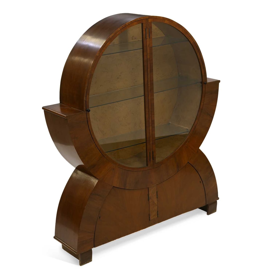 V AN ART DECO WALNUT VITRINE: V AN ART DECO WALNUT VITRINE the circular case with a pair of glazed doors enclosing three glass shelves, the base with a pair of cupboard doors. 162cm high, 135cm wide, 30cm deep