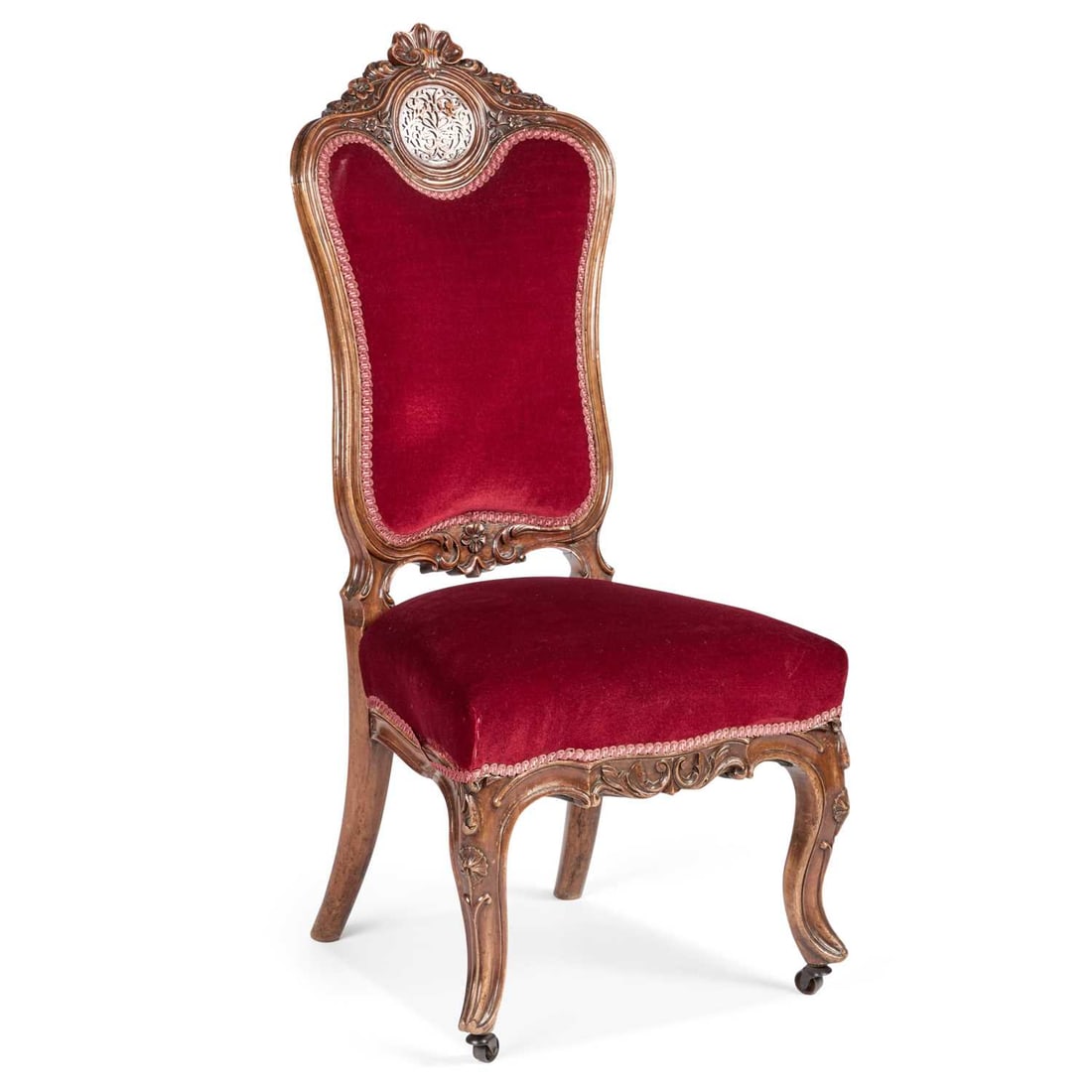A VICTORIAN WALNUT AND UPHOLSTERED HIGH-BACK CHAIR: A VICTORIAN WALNUT AND UPHOLSTERED HIGH-BACK CHAIR with a fret-carved roundel to the carved crest. Height of back 105cm