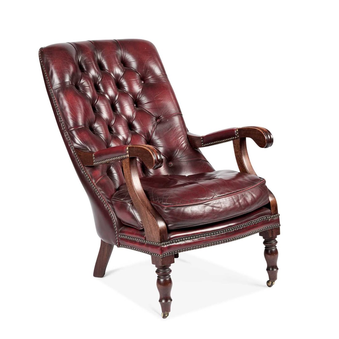 A REGENCY STYLE LEATHER UPHOLSTERED MAHOGANY LIBRARY CHAIR: A REGENCY STYLE LEATHER UPHOLSTERED MAHOGANY LIBRARY CHAIR with a deep-buttoned back and a loose cushion. Height of back 88cm