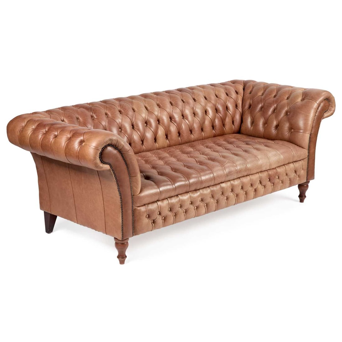 A DEEP-BUTTONED TAN LEATHER CHESTERFIELD SOFA: A DEEP-BUTTONED TAN LEATHER CHESTERFIELD SOFA with turned forelegs. 217cm long