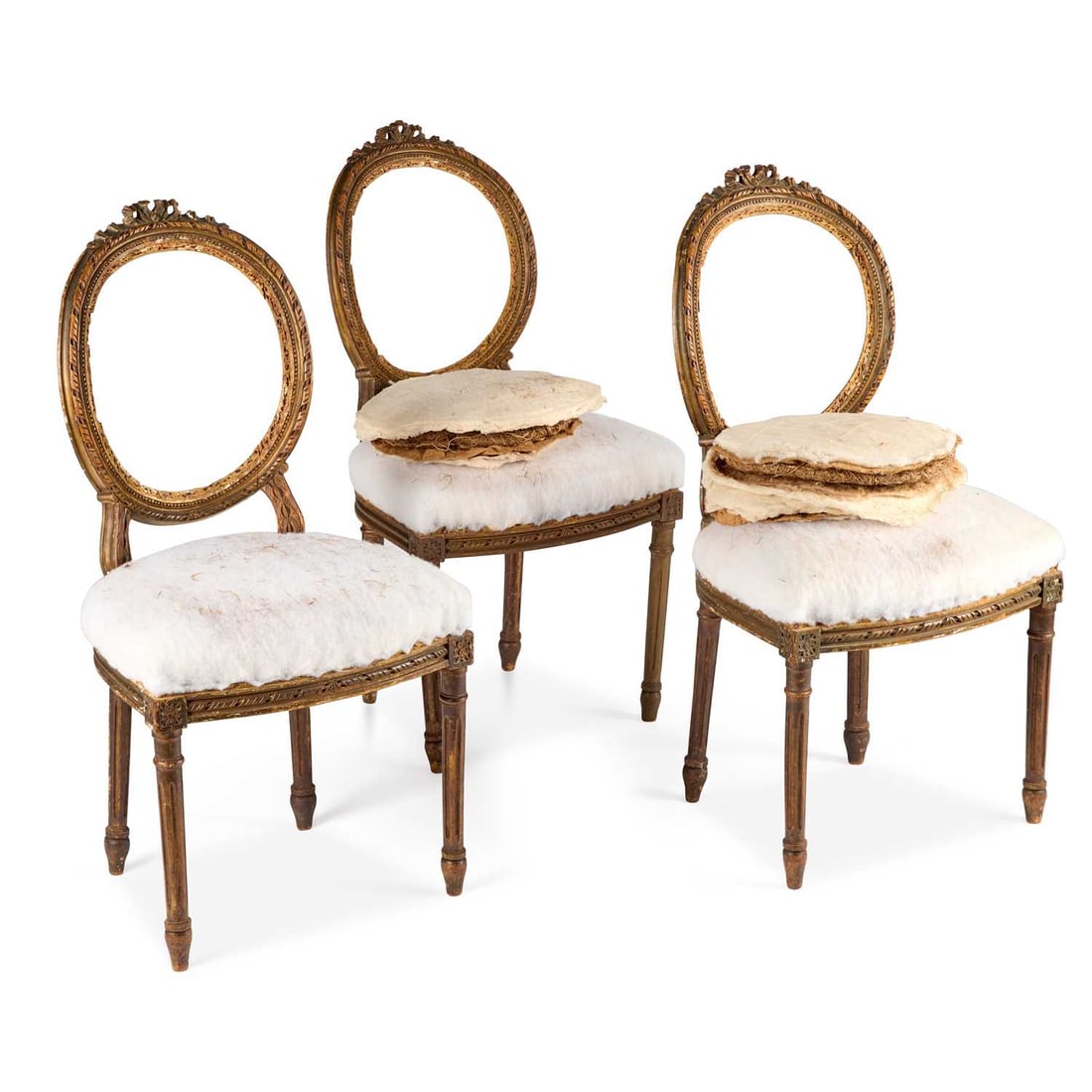 THREE FRENCH LOUIS XVI STYLE CARVED OVAL-BACK CHAIRS 19TH CENTURY: THREE FRENCH LOUIS XVI STYLE CARVED OVAL-BACK CHAIRS 19TH CENTURY each with a floral cresting above a beaded and foliate-carved oval back, raised on fluted tapering legs. (3) Height of backs 90cm