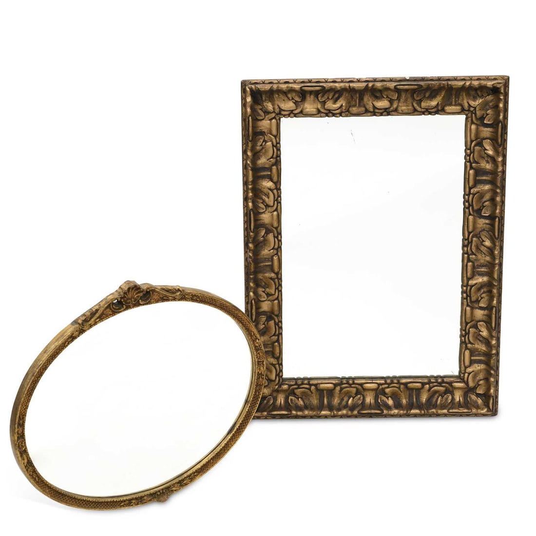 V TWO GILT-COMPOSITION WALL MIRRORS: V TWO GILT-COMPOSITION WALL MIRRORS comprising a rectangular example with moulded foliate decoration; and an oval example with ribbon-tied crest and incised frame. (2) Rectangular mirror 78cm by 58cm