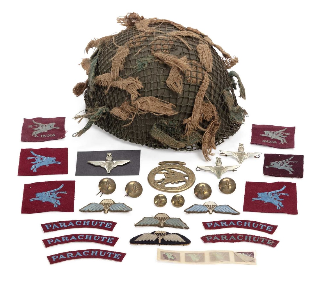 A SECOND WORLD WAR BRITISH AIRBORNE FORCES/ PARATROOPER HELMET: with camouflage net, stamped BMB for Briggs Motor Bodies Ltd size 71/4 and dated 1944, retaining the original liner and canvas chin strap; together with a group of Parachute Regiment cloth badges,