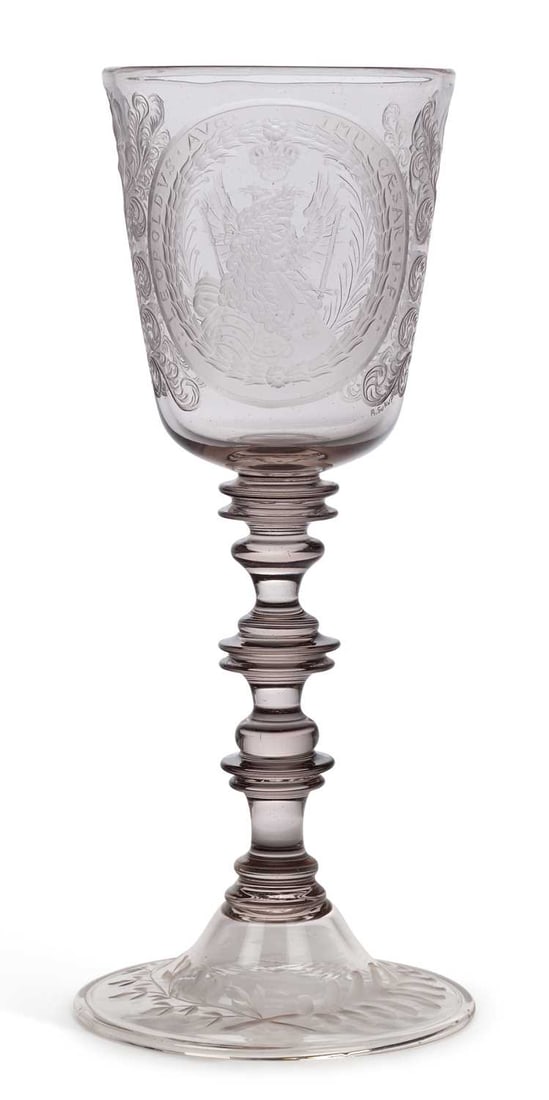 A BOHEMIAN ENGRAVED GLASS GOBLET: signed R. Sukup, engraved with the Imperial double headed eagle within a laurel oval inscribed IMP CAESAR LEOPOLDVS AVG P F, within foliate scroll borders, on a multi-knopped stem and engraved conical