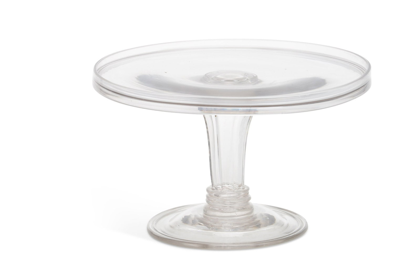 A GLASS TAZZA 18TH CENTURY: the shallow dished top raised on a ribbed pedestal stem with triple collars, on a domed folded foot with a rough pontil mark. 14cm high, 23cm diameter