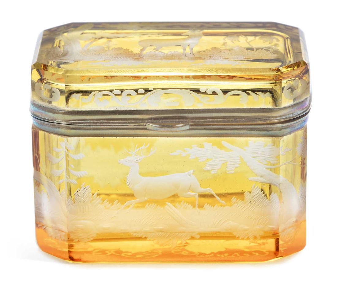 A BOHEMIAN AMBER FLASHED GLASS CASKET CIRCA 1880: engraved with scenes of deer in woodland, the cover attached with gilt-metal mounts and similarly decorated. 8.5cm wide
