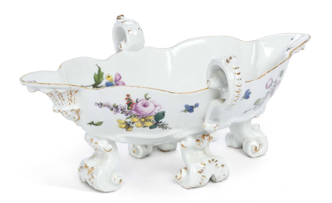A MEISSEN PORCELAIN SAUCEBOAT CIRCA 1740: double-handled, finely painted with sprays and sprigs of flowers, set upon four scroll feet, heightened in gilt, underglaze blue crossed swords mark. 24.5cm long