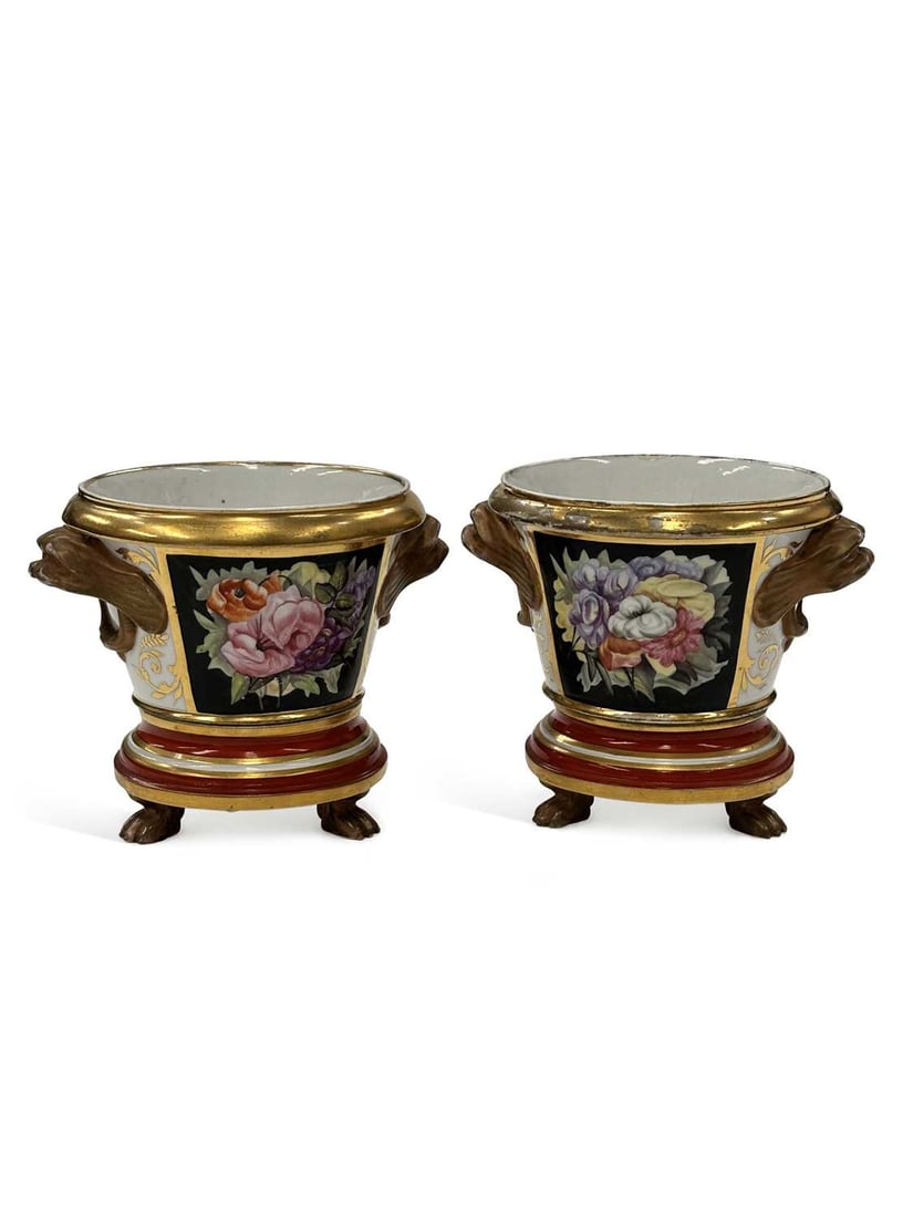 A PAIR OF ENGLISH PORCELAIN CACHEPOTS AND STANDS CIRCA 1820: each of campana form with gilt lion mask handles, painted with a panel of garden flowers reserved on a black ground, the reverse with iron-red and gilt anthemion and scrolling foliage, on a stepped st