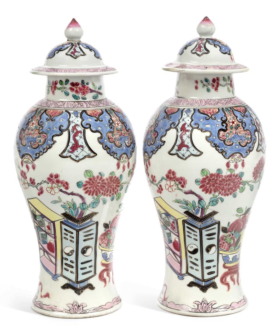 A PAIR OF SAMSON CHINESE STYLE VASES AND COVERS CIRCA 1890: each of baluster form, decorated in Chinese famille rose style, with flowering plants and fruit amongst tables and vases. (2) 32cm high Hair crack to base of one of the vases, one of the covers has be
