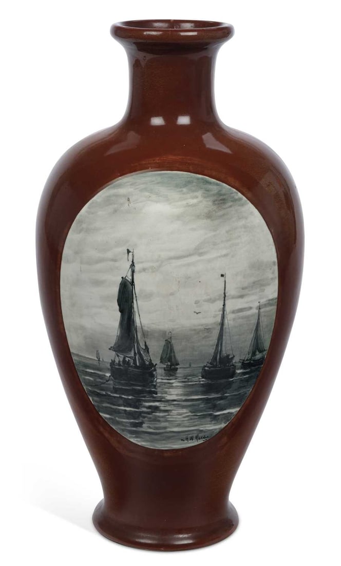 A ZUID-HOLLAND GOUDA POTTERY VASE EARLY 20TH CENTURY: of baluster form with a flared neck, painted en grisaille within an oval reserve with Dutch fishing boats becalmed at sea, after Hendrik Willem Mesdag and signed n. H.W. Mesdag, on a treacle brown gro