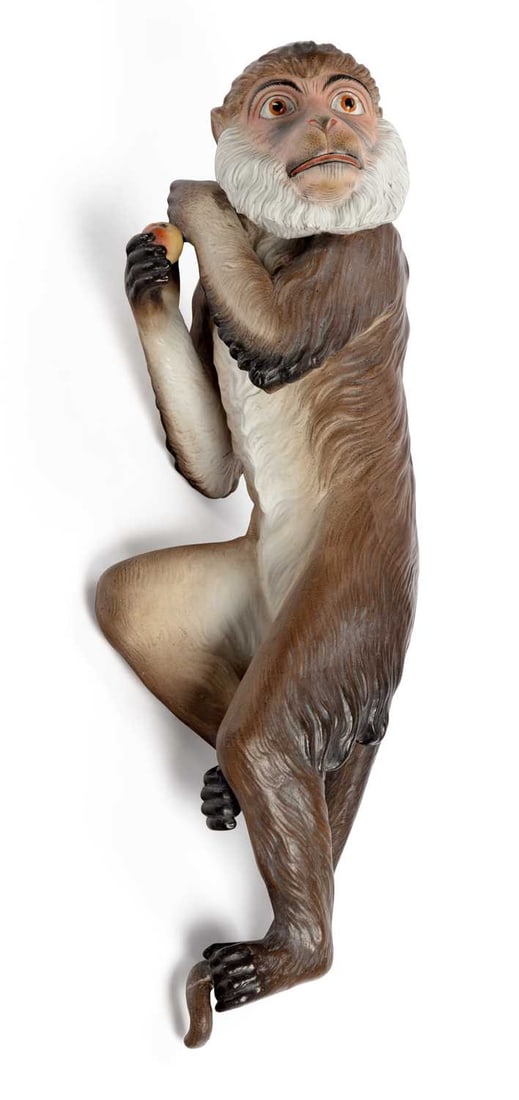 A GERMAN BISQUE MONKEY CIRCA 1890: well modelled as a monkey holding an apple, climbing an imaginary vine. 29.5cm long