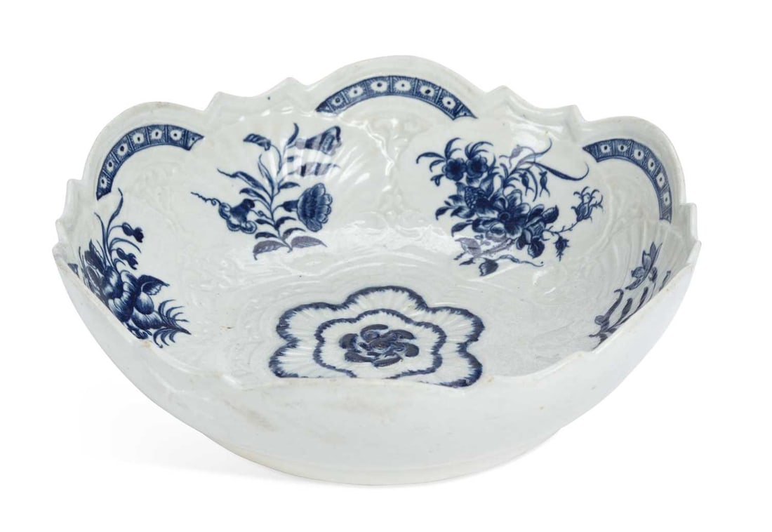 A WORCESTER PORCELAIN JUNKET DISH CIRCA 1765: the porcelain dish lightly moulded with shells and scroll, painted in blue with the Junket Dish Florals pattern, Crescent mark in blue. 24cm diameter