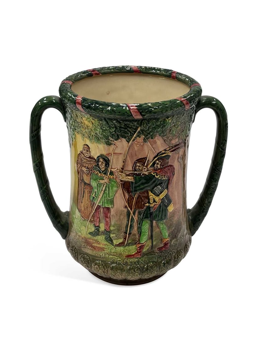 A ROYAL DOULTON LIMITED EDITION 'ROBIN HOOD AND HIS MERRY MEN, IN SHERWOOD FOREST' LOVING CUP CIRCA: two-handled, relief moulded with figural scenes, edition number 72, designed by Noke and Fenton. 22cm