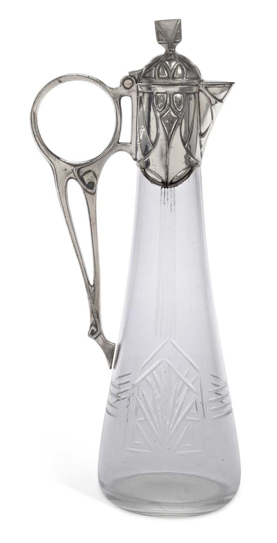 A WMF PEWTER LIQUEUR JUG CIRCA 1900: the glass engraved in Art Nouveau style, the pewter mounts cast with similar stylised decoration, and having a hinged domed cover. 25.5cm high