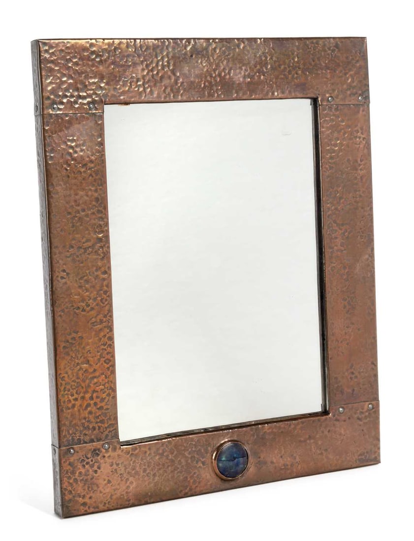 AN ARTS AND CRAFTS COPPER MIRROR CIRCA 1910: rectangular, with a planished finish, inset with a Ruskin type high fired roundel. 36.2cm high, 29cm wide