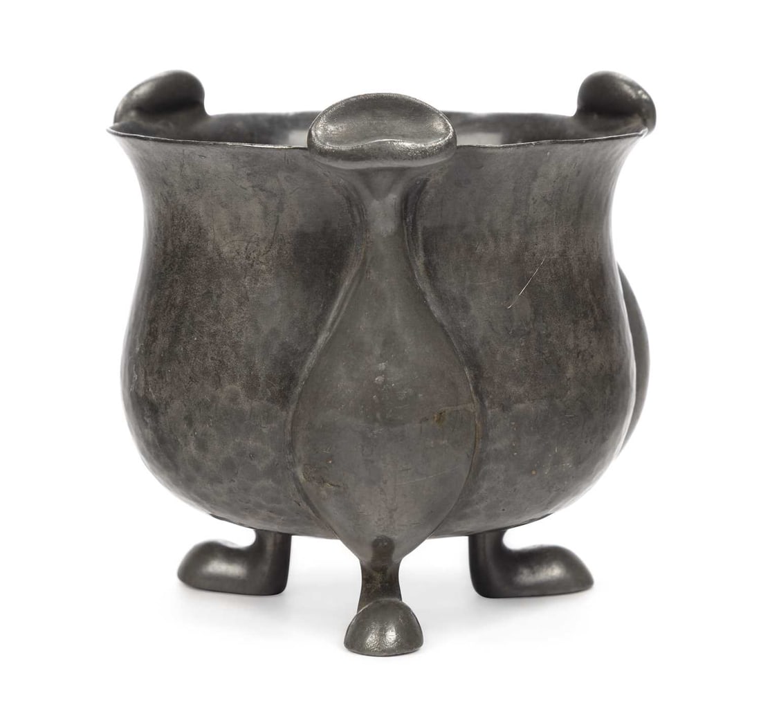 OLIVER BAKER FOR LIBERTY & CO, A TUDRIC PEWTER BOWL: with a planished finish, and set upon three pod feet, stamped ENGLISH PEWTER, model number 01029 to the base. 10.5cm wide