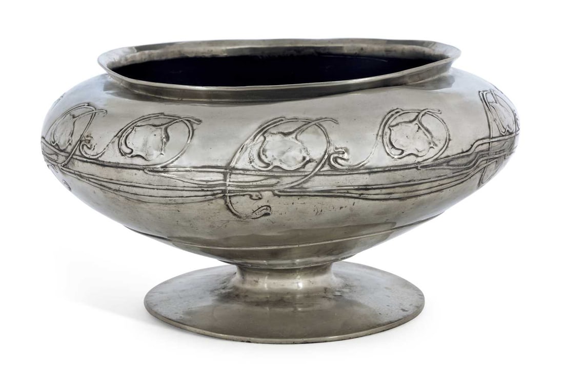 ARCHIBALD KNOX (1864-1933) FOR LIBERTY & CO A LARGE TUDRIC PEWTER BOWL: circular form, decorated with a continuous band of stylised leaves and vine, raised on a pedestal foot, stamped marks. 41cm diameter, 22cm high
