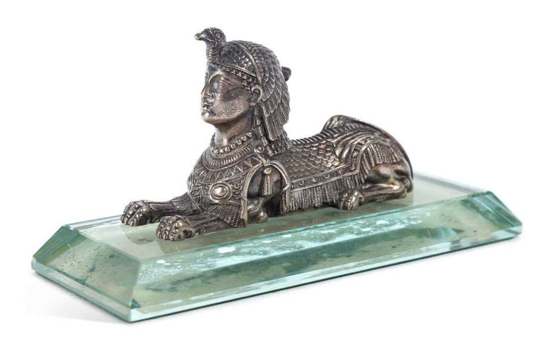 A 19TH CENTURY ENGLISH SILVER-PLATED SPHINX PAPERWEIGHT: the Sphinx well cast and recumbent upon a rectangular glass base. 15.2cm long