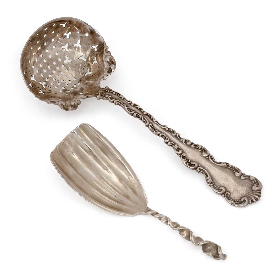 AN AMERICAN STERLING SILVER SIFTER SPOON AND CADDY SPOON 20TH CENTURY: the sifter spoon with scroll borders and shell terminal, the bowl with foliate pierced decoration; the caddy spoon with a twist handle. (2) Sifter spoon 14cm long, 1.3 troy ounces gross