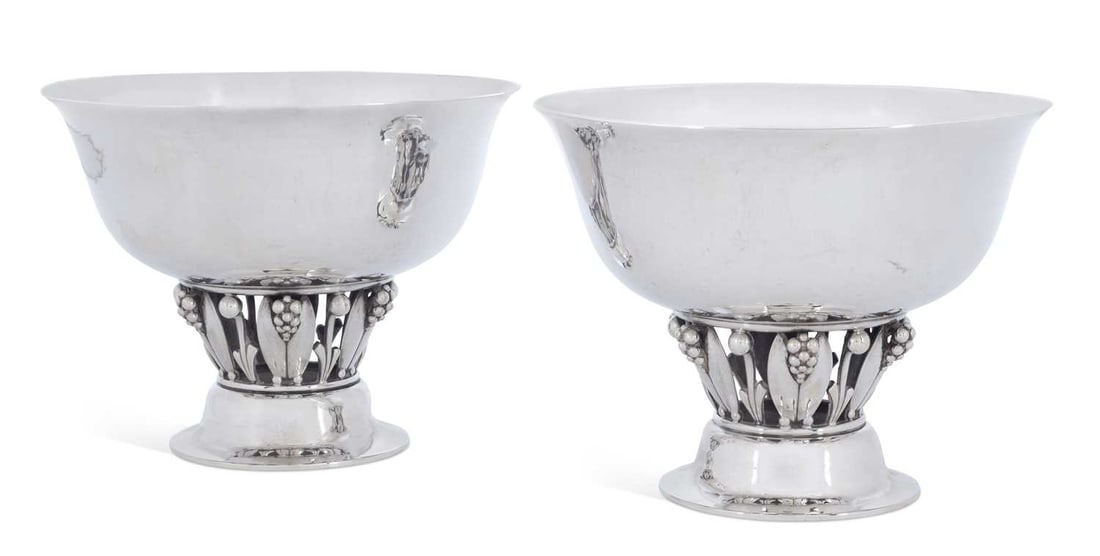 GEORG JENSEN, A PAIR OF DANISH STERLING SILVER BOWLS: by Georg Jensen, import marked London 1963, of circular form with an openwork stem embellished with foliage and berries and a pedestal foot, each with a planished bowl, model no. 197 B. (2) 11cm high,