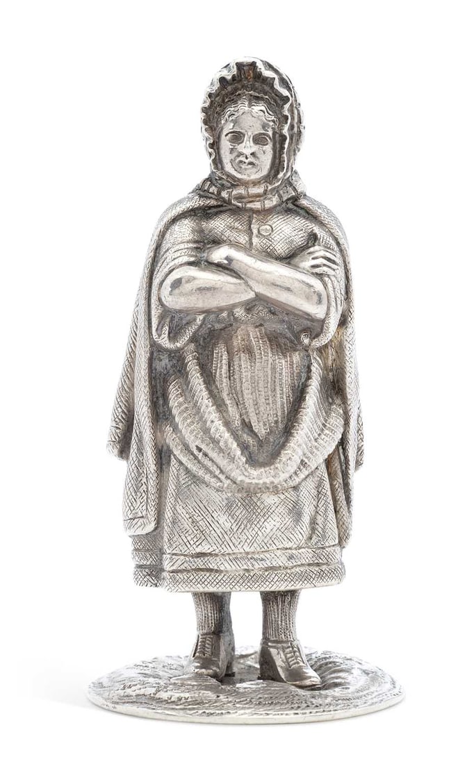 A GEORGE V SCOTTISH SILVER NOVELTY PEPPERETTE: by William Hamilton & Son, Edinburgh 1926, cast in the form of a female figure standing with crossed arms wearing a headscarf and shawl, with a screw-off base. 9cm high, 4.6 troy ounces