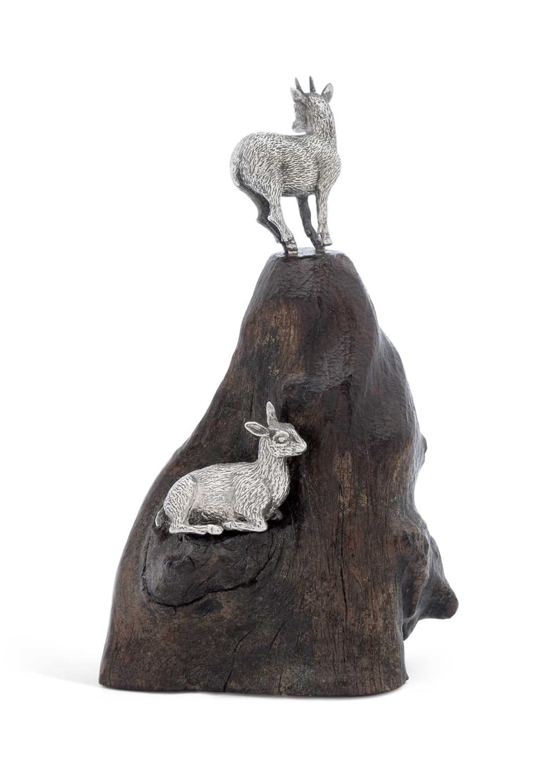 PATRICK MAVROS: A PAIR OF SILVER KLIPSPRINGERS: Zimbabwe hallmarks, mounted to a dark wooden base formed as a rocky outcrop. 10cm high Good condition.